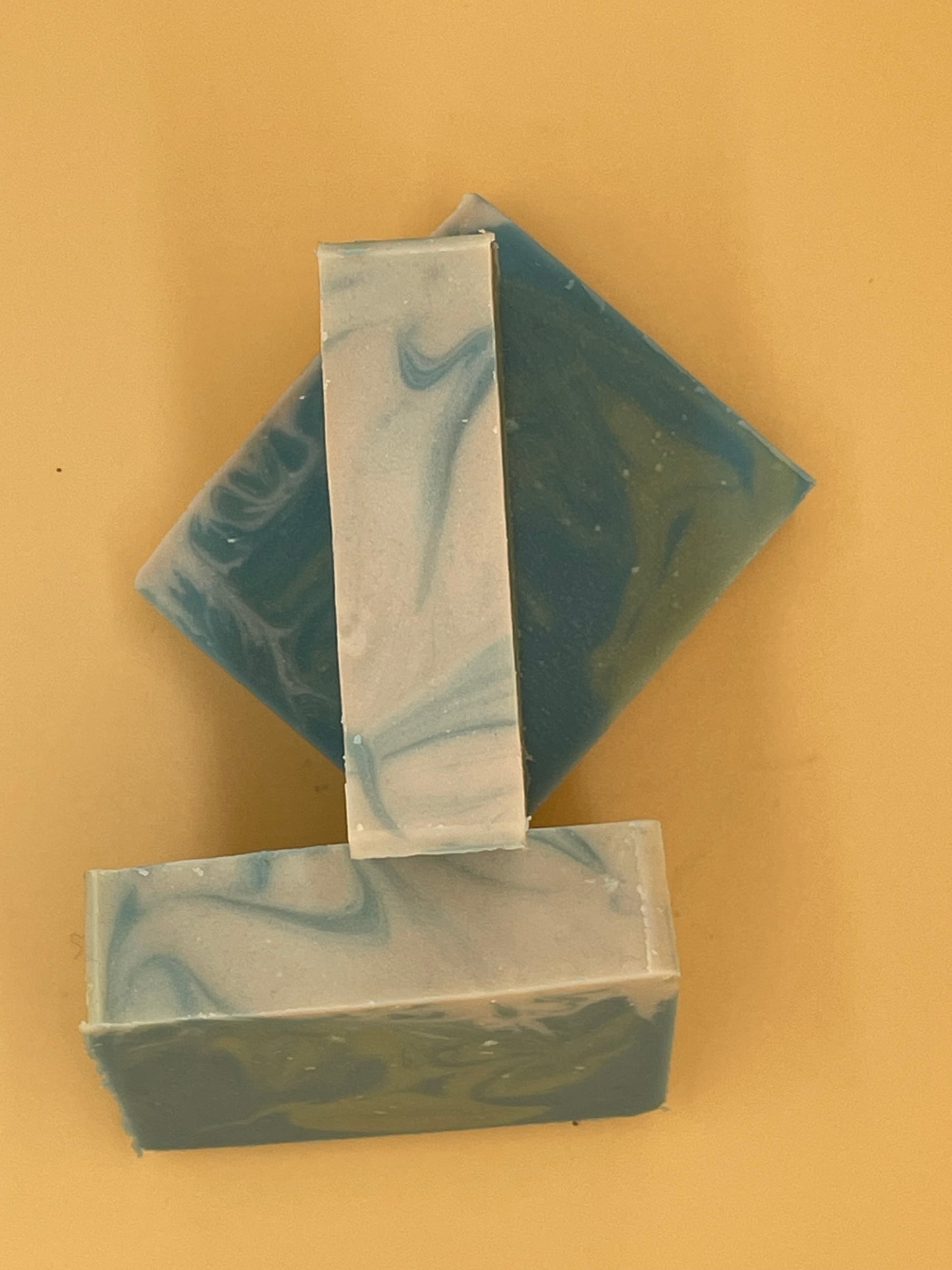 Top-down view of three Seafarer handmade tallow soap bars arranged on yellow background